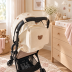 Petit sac à langer ourson fixé à une poussette dans une chambre bébé