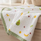 Détail de la texture d’une couverture bébé en gaze de coton motif avocats