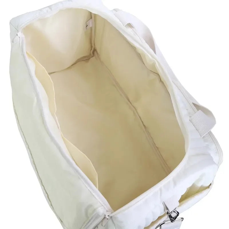 Intérieur spacieux du grand sac à langer matelassé écru