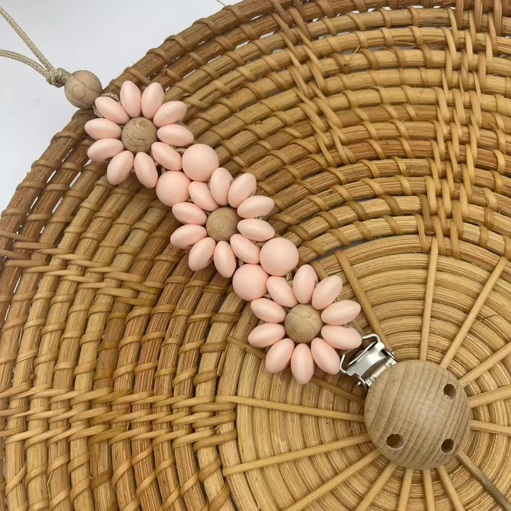 Attache Tétine Petite Fleur Marguerite, un accessoire joli et pratique pour garder la tétine à portée de main.