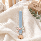 Attache-tétine en tissu bleu pastel avec nœud fleuri et pince en bois