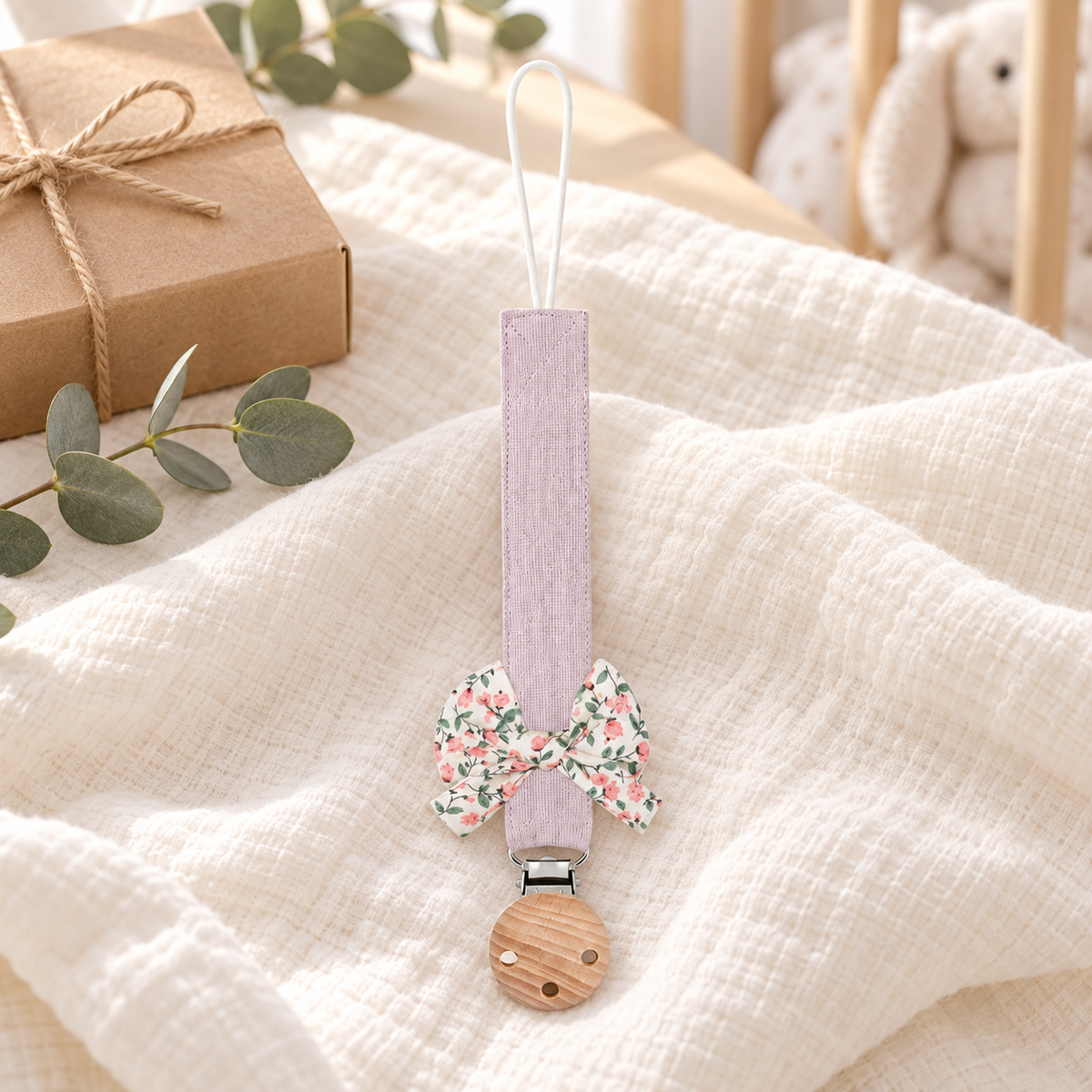 Attache-tétine en tissu lilas avec nœud fleuri et pince en bois