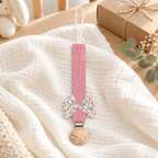 Attache-tétine en tissu rose framboise avec nœud fleuri et pince en bois