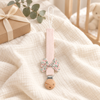 Attache-tétine en tissu rose poudré avec nœud fleuri et pince en bois
