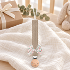 Attache-tétine en tissu taupe avec nœud fleuri et pince en bois