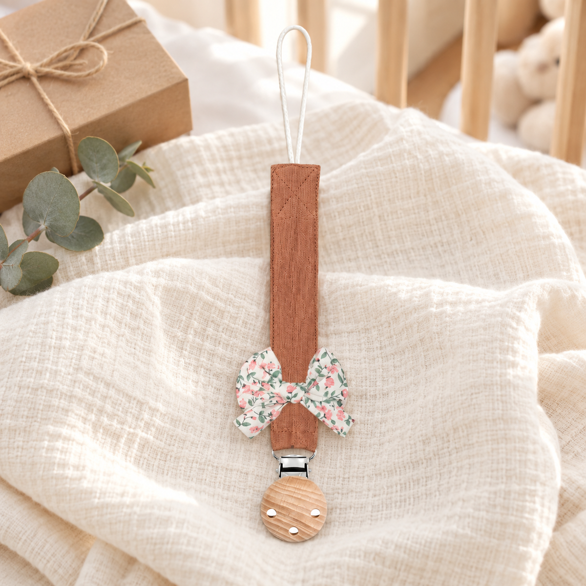 Attache-tétine en tissu terracotta avec nœud fleuri et pince en bois