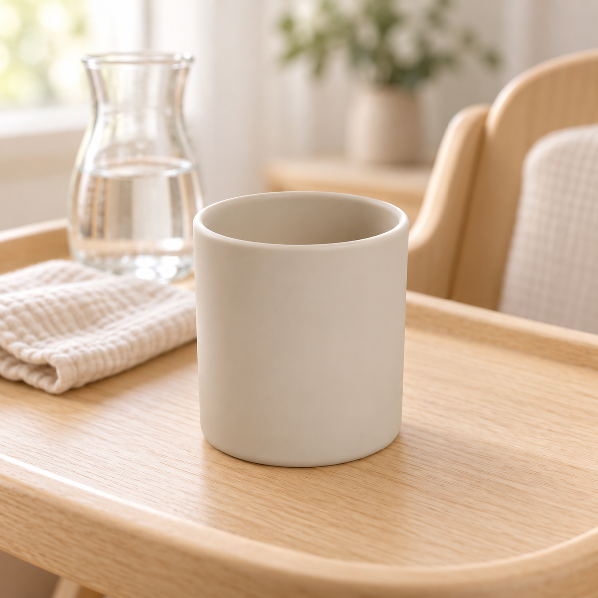 Gobelet bébé en silicone beige sable sur chaise haute