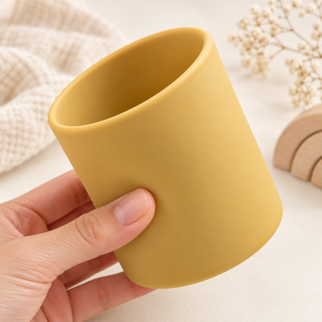 Détail de la souplesse du gobelet bébé en silicone moutarde