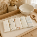 Lot de lingettes bébé en coton et gaze sur une table à langer